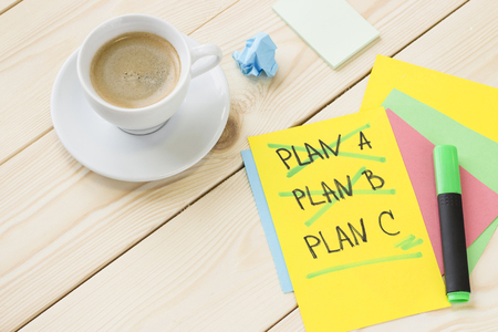 Inspiration and motivation concept. A cup of coffee, colored papers with inscriptions and a green highlighter.の写真素材