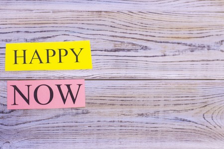 Happy now printed inscription on a light wooden background.の写真素材