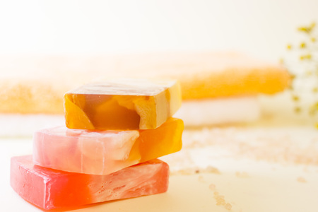 Spa, massage, bath accessories, aromatherapy concept. Three bars of colorful fruit soap in a close...