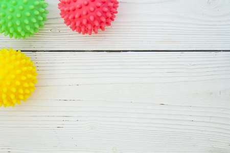 Pet care, veterinary, grooming concept. A white wooden background with a corner of pet toys - colorful rubber squeaky balls. Space for your your text or product display.の写真素材