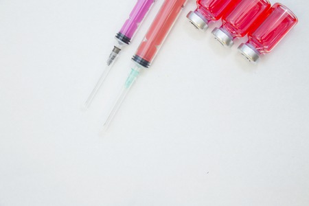 Veterinary and animal healthcare background. Curing pets. Three ampouls with red cure and two syringes, close up. Space for your text or image.の写真素材