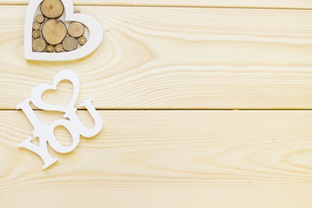 I love you inscription and wooden toy heart on wooden background, close up, top view. Concept of St.Valentine's Day, anniversary, weddingの写真素材