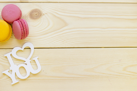 I love you inscription and colorful macaroons on wooden background, close up, top view. Concept of St.Valentine's Day, anniversary, weddingの写真素材