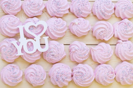 Pink marshmellows with I Love You inscription for Valentine's Day w on a wooden boad, top viewの写真素材