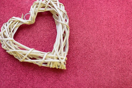 Concept of Valentine's Day with white woven heart glitter red background, top viewの写真素材