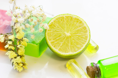 Spa, Aromatherapy, Natural Cosmetic concept with soap, glass bottles of essential oil and lime white background, close upの写真素材
