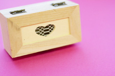 St. Valentine's Day or Anniversary concept with a wooden jewellery casket, pink background,close up