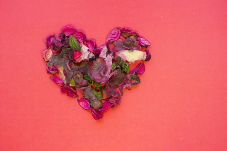 The concept of St.Valentine's Day with heart made of rose petals, red background top view, copy spaceの写真素材