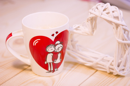 Concept of St.Valentine's Day, Love, Anniversary, Wedding with a white porcelian mug decorated with a heart image and I Love You inscription on a wooden tableの写真素材