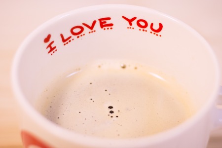 Concept of St.Valentine's Day, Love, Anniversary, Wedding with a white porcelian coffee mug decorated with I Love You inscription on a wooden table, close upの写真素材