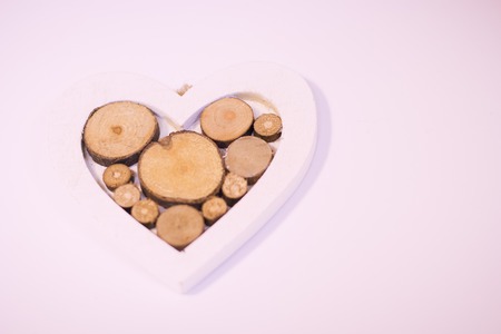 Concept of St.Valentine's Day, Love, Anniversary, Wedding with a wooden heart with tree circles in a close up, light backgroundの写真素材