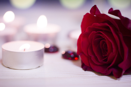 The concept of Love, Wedding, Proposal, Anniversary. A romantic evening with burning aroma candles and a beautiful red velvet rose, blurred background, top viewの写真素材