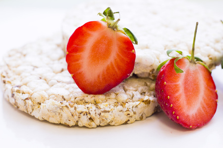Healthy Breakfast Concept with wheat breadcrisps and fresh cut strawberries on white, close up, copy spaceの写真素材