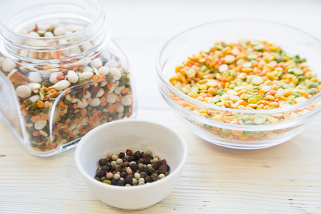 Preparing Healthy Food, Kitchen Concept. Cooking ingredients on awhite wooden table: bowls with colorful beans and pepper cornsの写真素材
