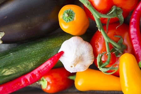 Preparing Healthy Food, Vegeterian, Vegan Concept. A close up of fresh whole vegetables: zuccini, eggplant, tomatoes, chilli peppers and garlic, top viewの写真素材