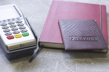 Business Wokplace, Analysis, Payment Concept with EDC machine or credit card terminal, a dayplanner and a passport, grey concrete backgroundの写真素材