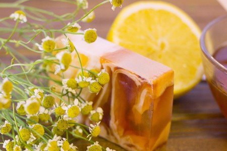 Set of sugaring essentials lemon, camomile and a bar of soap on a natural dark wooden backgroundの写真素材