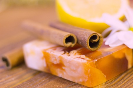 A close up of spa essentials with fruit soap, lemon and cinnamon sticks on a natural dark wooden backgroundの写真素材