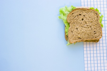 A rye bread sandwich, top view, blue and white squared paper backgroundの写真素材