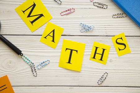 Maths inscription and paper clips on white wooden background, top view, copy spaceの写真素材