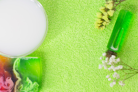 Fruit aromatherapy spa concept with essential oil in glass bottles, soap bars, jelly lotion and lime mock up, green background, closupの写真素材
