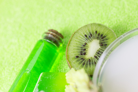 Fruit aromatherapy spa concept with essential oil in glass bottles, soap bars, jelly lotion and lime mock up, green background, closupの写真素材