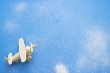 Blue powdered background with toy airplaneの写真素材