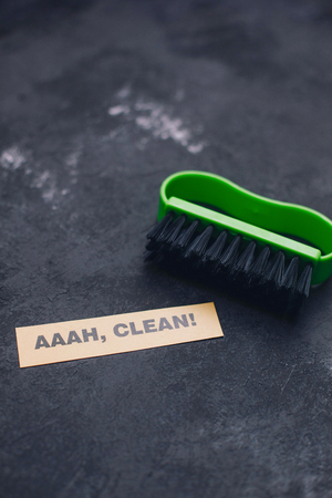 Cleaning house or office concept. Green cleaning brush, AAAH, clean inscription on a dark concrete background. Top view, closeupの写真素材