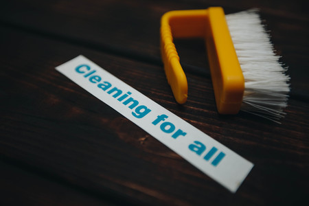 Cleaning house or office concept. Yellow cleaning brush, Cleaning for all inscription on a dark wooden background. Top view, closeupの写真素材