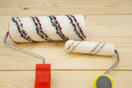 Repair, Redecorating Concept. Paint rollers on a light uncolored wooden background, close upの写真素材