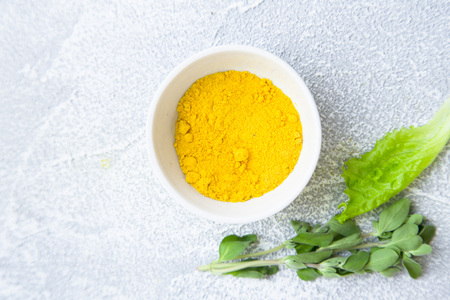 Dry spices in a ceramic bowl,fresh herbs on a light stone background with copy space, top viewの写真素材