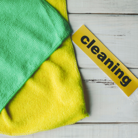 Keep your house clean and healthy with a fluffy yellow and green cotton mop. Contrast composition of cleaning tools, white wooden background. Top view.の写真素材