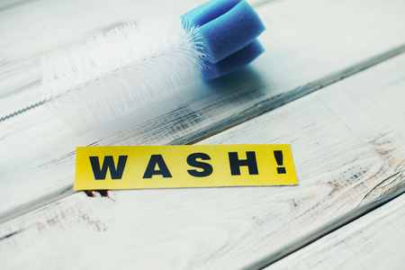 Cleaning house or office concept. Blue cleaning brush and WASH inscription on a white wooden background. Top view, closeupの写真素材