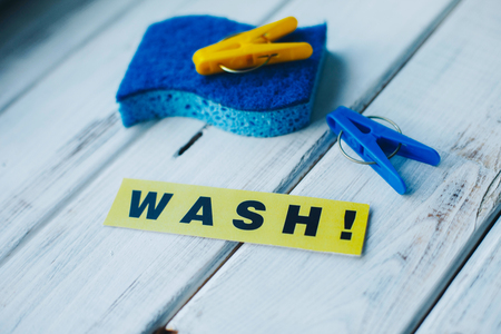 Cleanup in a kitchen. A bright abstract composition with scrub dishwashing sponges and clothes pegs on a white wooden background. Close upの写真素材