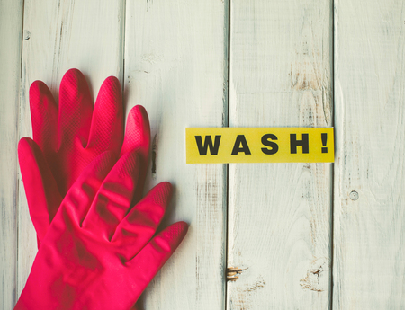 A bright composition with a pair of pink latex gloves on white wooden surface. Top viewの写真素材