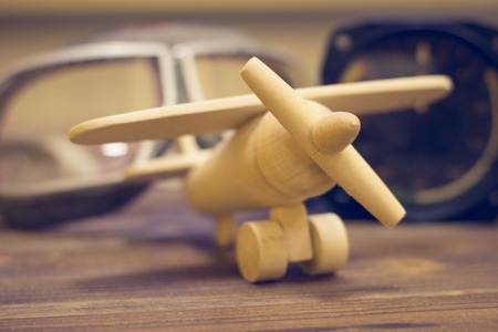 Travel, Sport Concept. A toy wooden plane, a swimming mask and a speed counter on a blurred background, selective focus, close upの写真素材