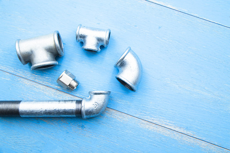 Various plumbers tools and plumbing materials including stainless steel pipe, elbow joint, wrench...