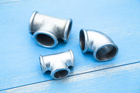Various plumbers tools and plumbing materials including stainless steel pipe, elbow joint, wrench...