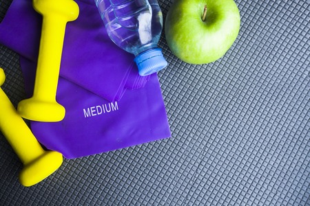 Time for diet slimming weight loss concept. Sport fit fitness, measuring tape and yellow weights on...