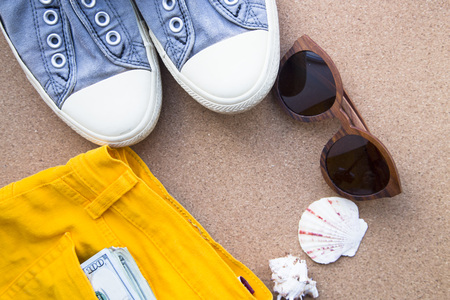 Preparing for vacation, travel or journey. Travel planning. Booking hotel. Sand background with strawberry, sneakers, sunglasses, passport, seashells, camera and compass.の写真素材