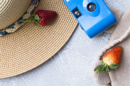 Preparing for vacation, travel or journey. Travel planning. Booking hotel. Grey marble background with sunglasses, slippers, seashells, hat and strawberry.の写真素材