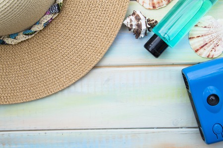 Preparing for vacation, travel or journey. Travel planning. Booking hotel. White wooden background with sunglasses, hat, seashells and strawberry.の写真素材