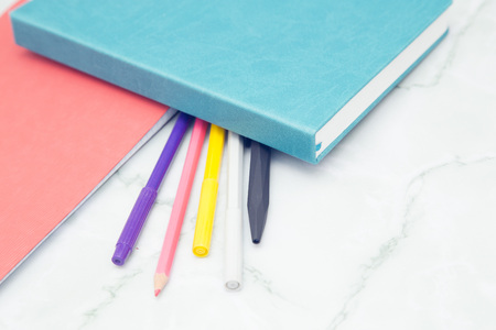 Notepad with pencils and colorfull markers on wood board background. Education or business photo. Take note of the product for book with paper and concept or copy space.の写真素材