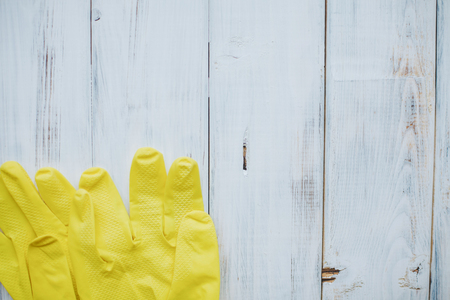 Cleaning house or office concept. A white wooden background with yeellow rubber gloves, top view, flat layの写真素材