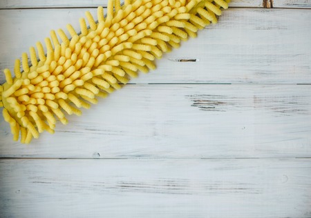 Cleaning house or office concept. A yellow microfiber mop on a white wooden background, close up, top viewの写真素材