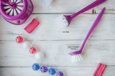 Cleaning house or office concept. A set of purple toilet cleaning tools on white wooden background, close up, top viewの写真素材