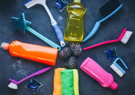 Cleaning house or office concept. A set of colorful cleaning supplies on black concrete background, top view, flat layの写真素材