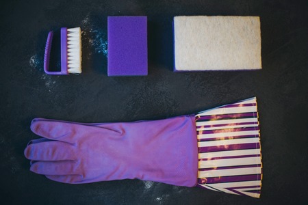 Cleaning house or office concept. A set of orange cleaning supplies on a dark concrete background, mock up,top view, flat layの写真素材