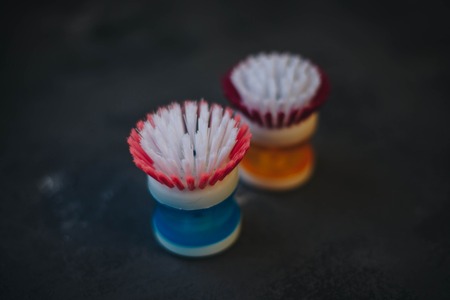 Cleaning house or office concept. Dish washing round brushes,close up, dark stone backgroundの写真素材
