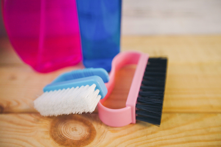 Cleaning house or office concept. Colorful plastic brushes and bottles with blue and pink liquid...